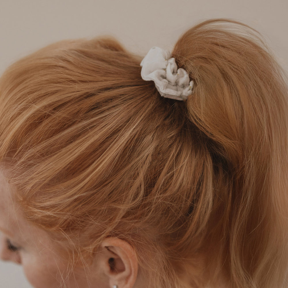 Scrunchie mit Blumenmuster im Pferdeschwanz von hinten getragen