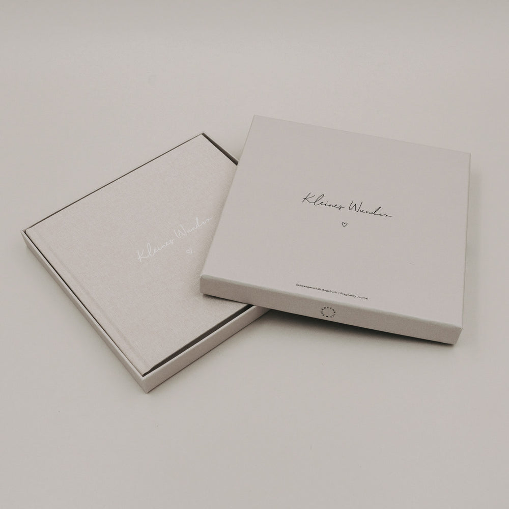 Schwangerschaftstagebuch „Kleines Wunder“ in eleganter Geschenkbox auf hellem Hintergrund.