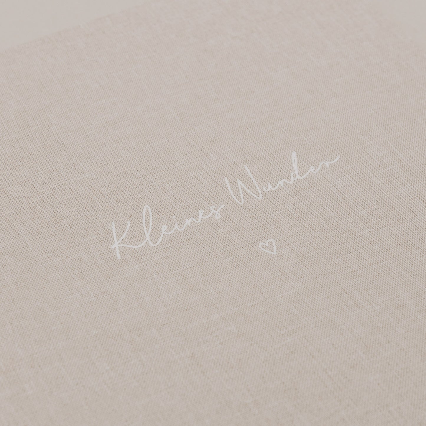 Nahaufnahme der geprägten Schrift „Kleines Wunder“ auf dem Stoffeinband.
