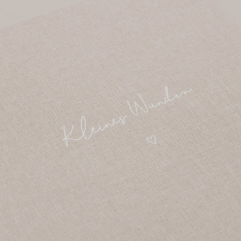 Nahaufnahme der geprägten Schrift „Kleines Wunder“ auf dem Stoffeinband.