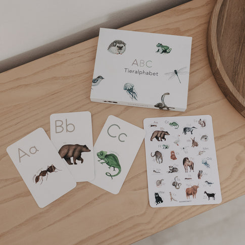 ABC Tieralphabet Karten-Set mit offenen Tierkarten auf Holzoberfläche.