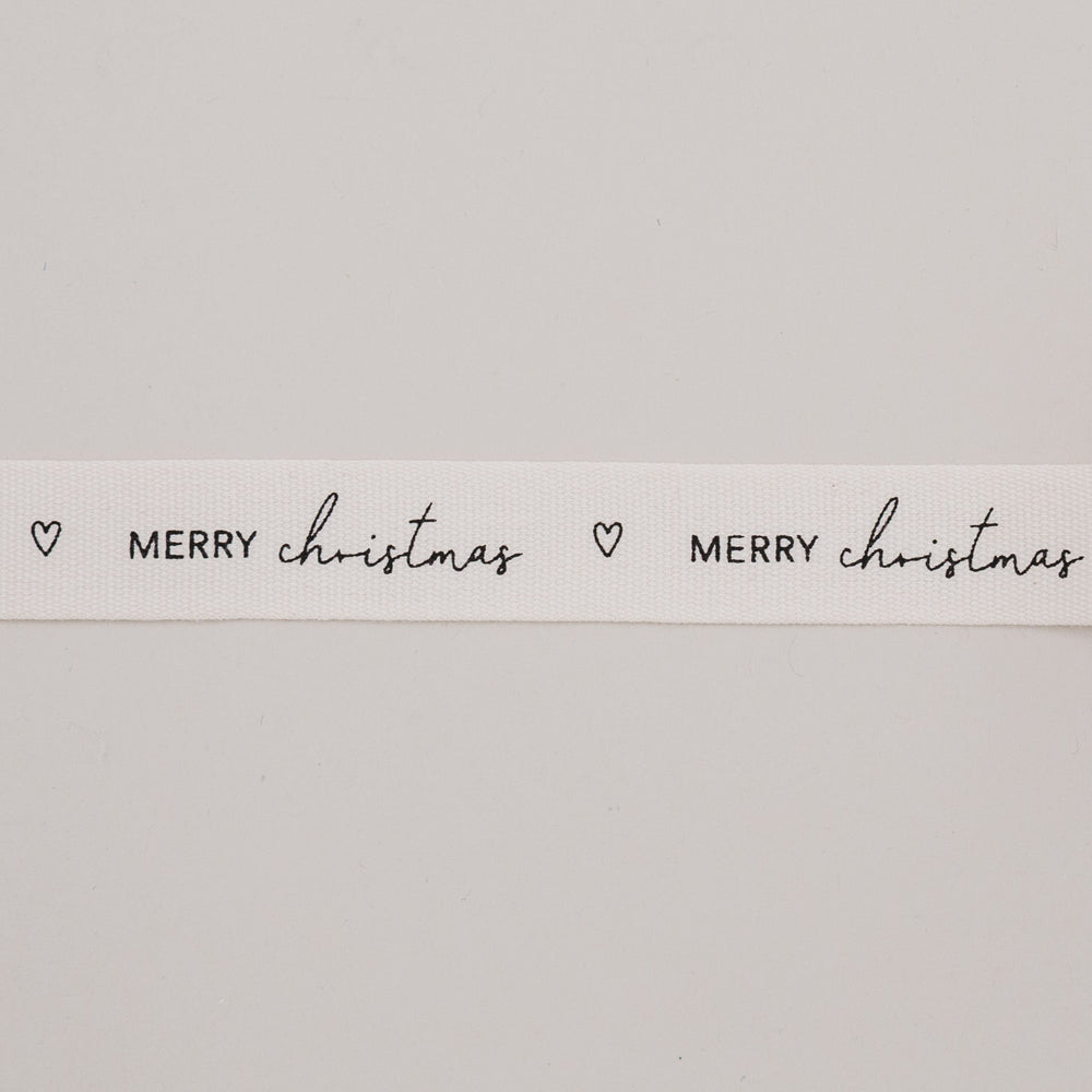Detailaufnahme Geschenkband Merry Christmas mit Herzmotiv auf naturweißem Baumwollband