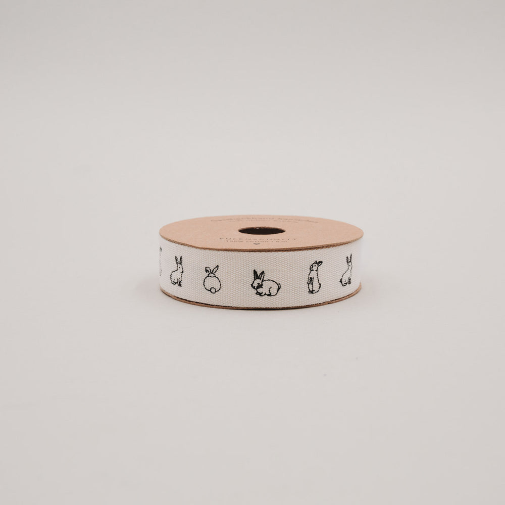 Seitliche Ansicht der Geschenkbandrolle mit Kaninchenillustrationen auf weißem Band.