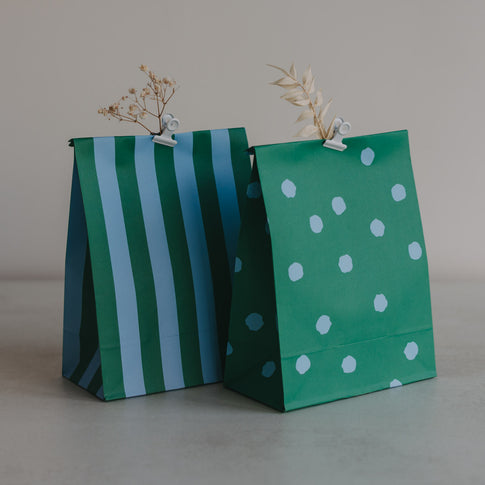 Zwei grüne Papiertüten mit Streifen und Punkten aus dem 6er Set, dekorativ arrangiert