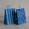Zwei blaue Papiertüten mit Streifen und Punkten aus dem Geschenkbeutel-Set
