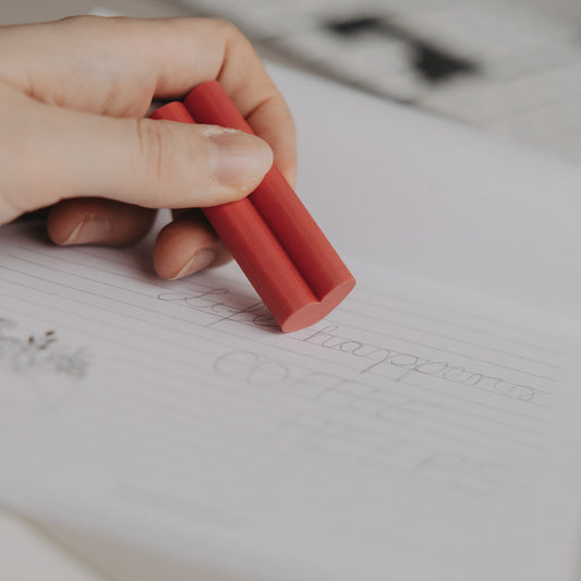 Hand radiert mit rotem Radiergummi in Herzform auf linierten Notizblock