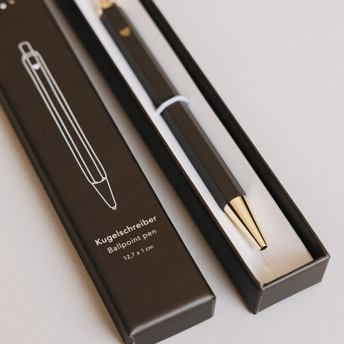 Detailansicht brauner Kugelschreiber in Box mit goldener Spitze und Herzdetail
