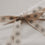 Beiges Eulenschnitt Geschenkband mit schwarzen Schneeflocken als Schleife auf weißem Geschenk
