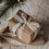 Geschenk mit beigem Geschenkband und schwarzen Sternen unter einem Weihnachtsbaum