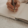 Kariertes A5 Notizbuch beim Schreiben mit Stift, Detailansicht der Innenseiten