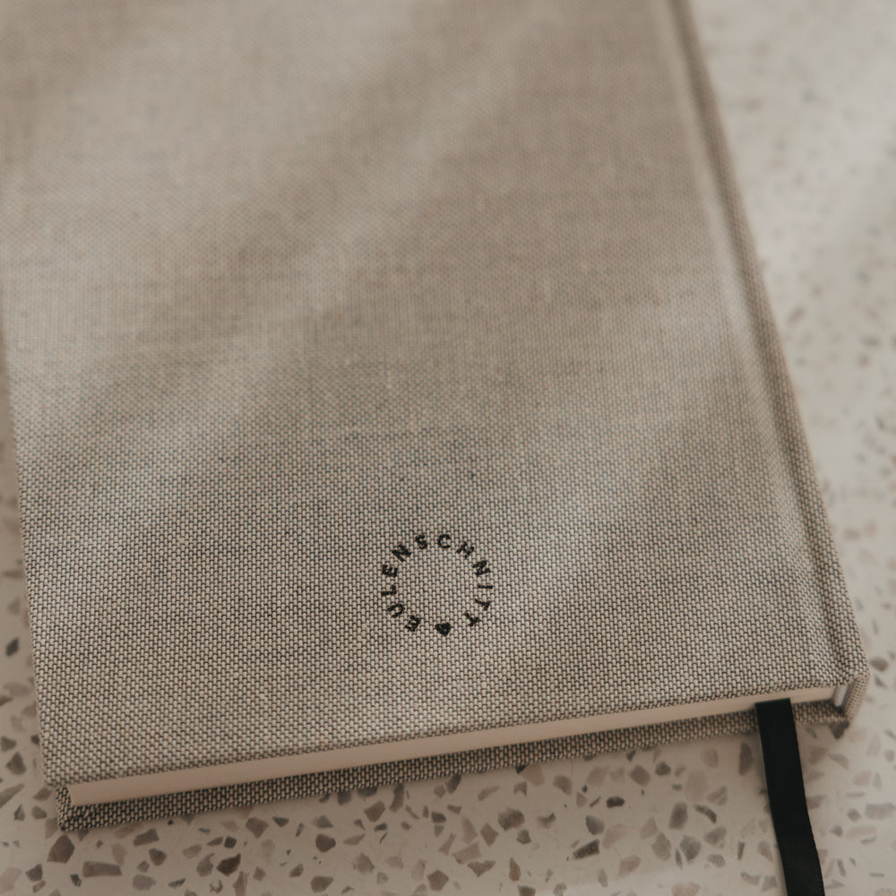 Rückseite des karierten A5 Notizbuchs mit Eulenschnitt Logo und schwarzem Leseband