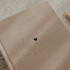 Beiges A5 Notizbuch mit Stoffeinband und kleinem schwarzem Herz auf der Vorderseite
