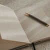 Offenes gepunktetes A5 Notizbuch mit Stift auf einer Seite