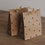 Zwei braune Geschenktüten aus Papier mit kleinen schwarzen Herzen, liebevoll dekoriert mit Holzklammern